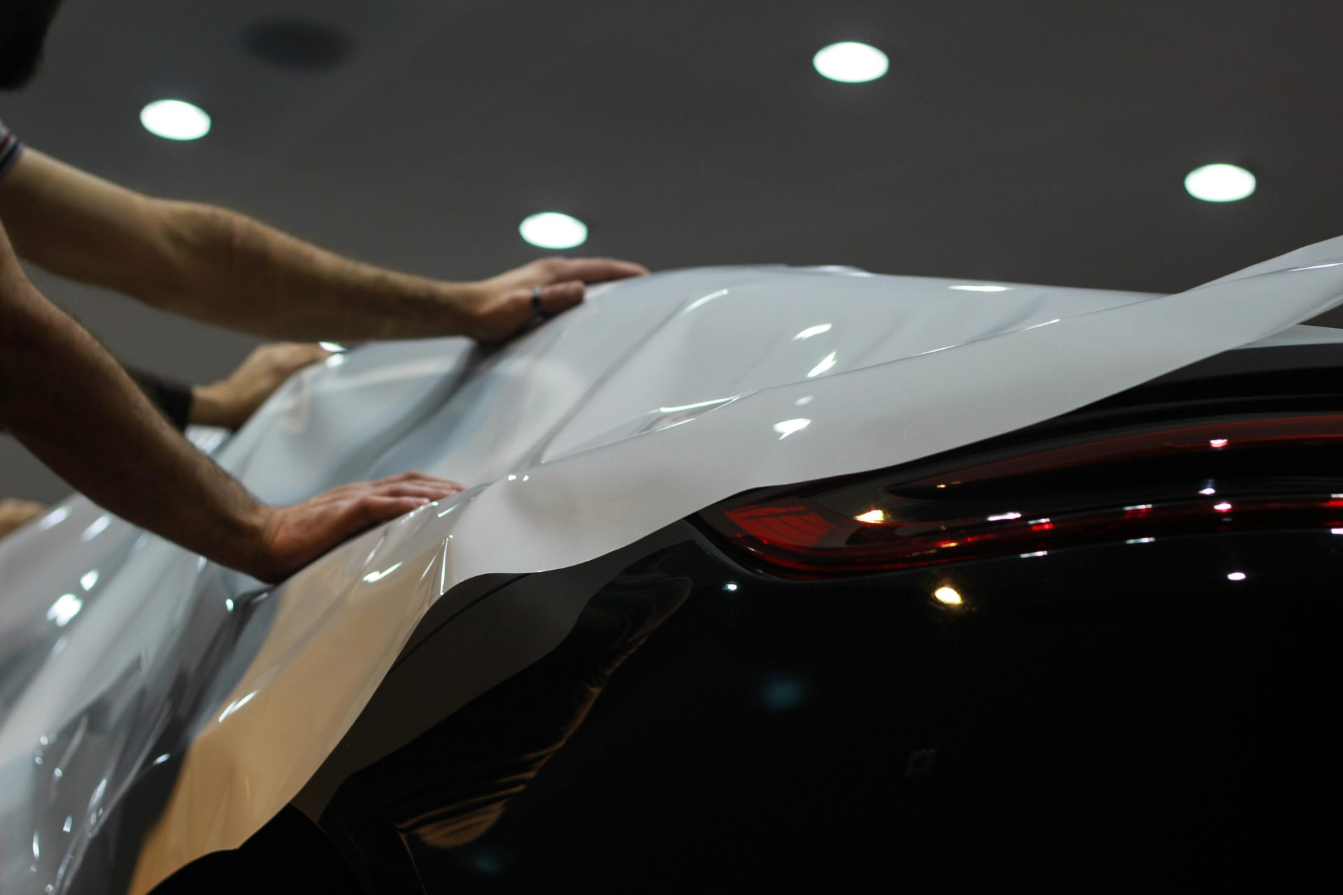 Professional car wrapping in progress, showcasing sleek modern vehicle enhancement.